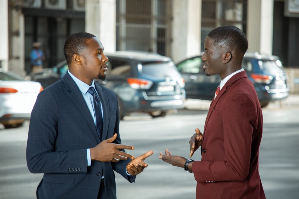 Two African men in conversation on a city street, talking openly in daylight