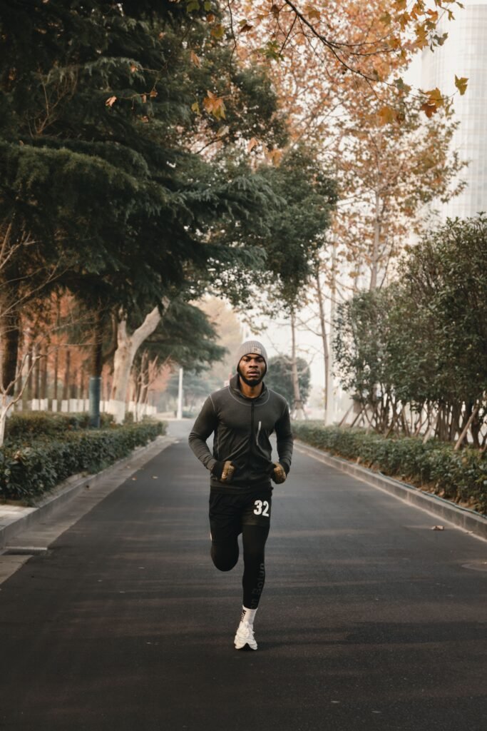 Man jogging along a tree-lined path in Abuja, Nigeria, in the early morning